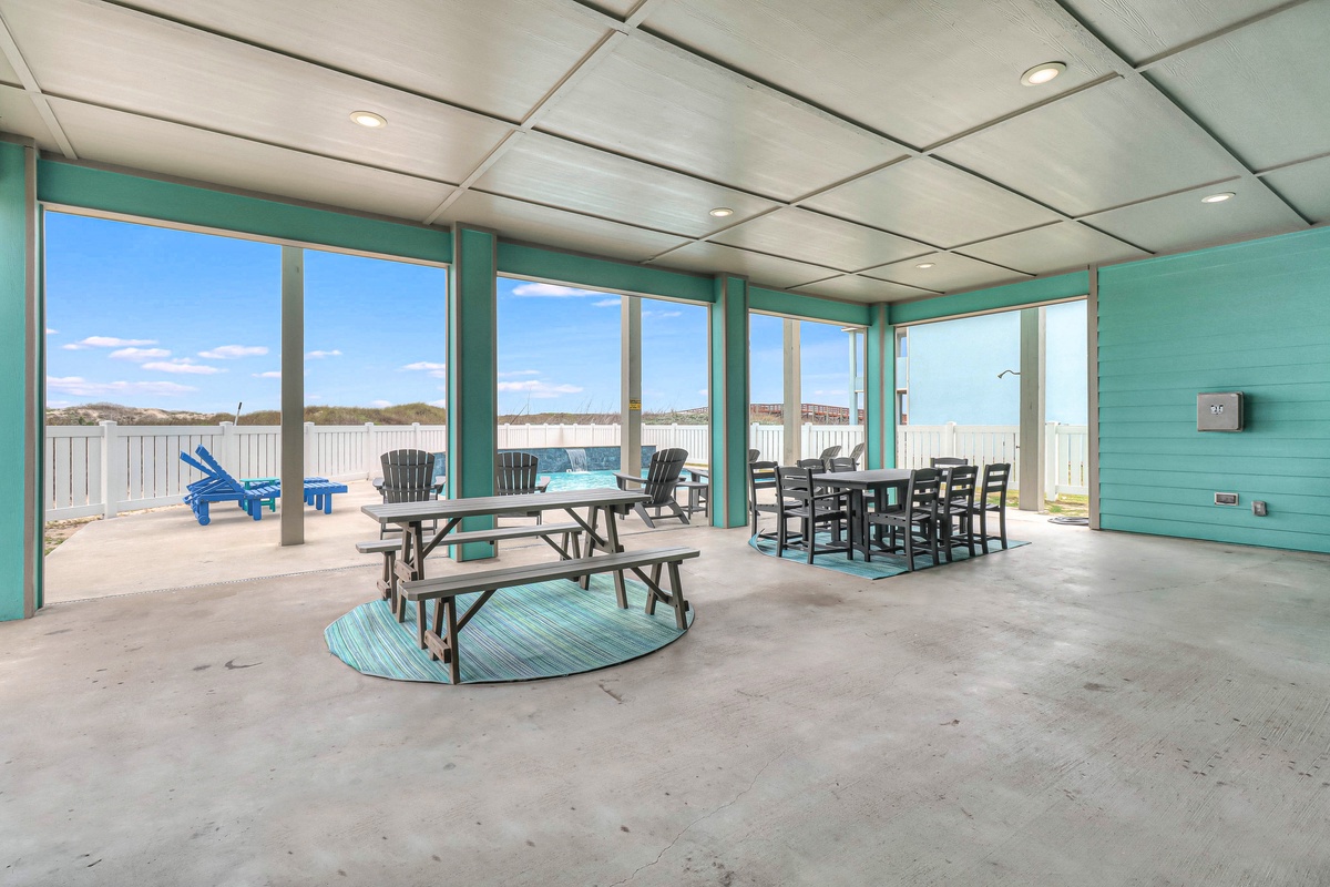 Gather with family at your beachside pavilion, featuring picnic tables and dining sets with stunning ocean views through floor-to-ceiling windows.