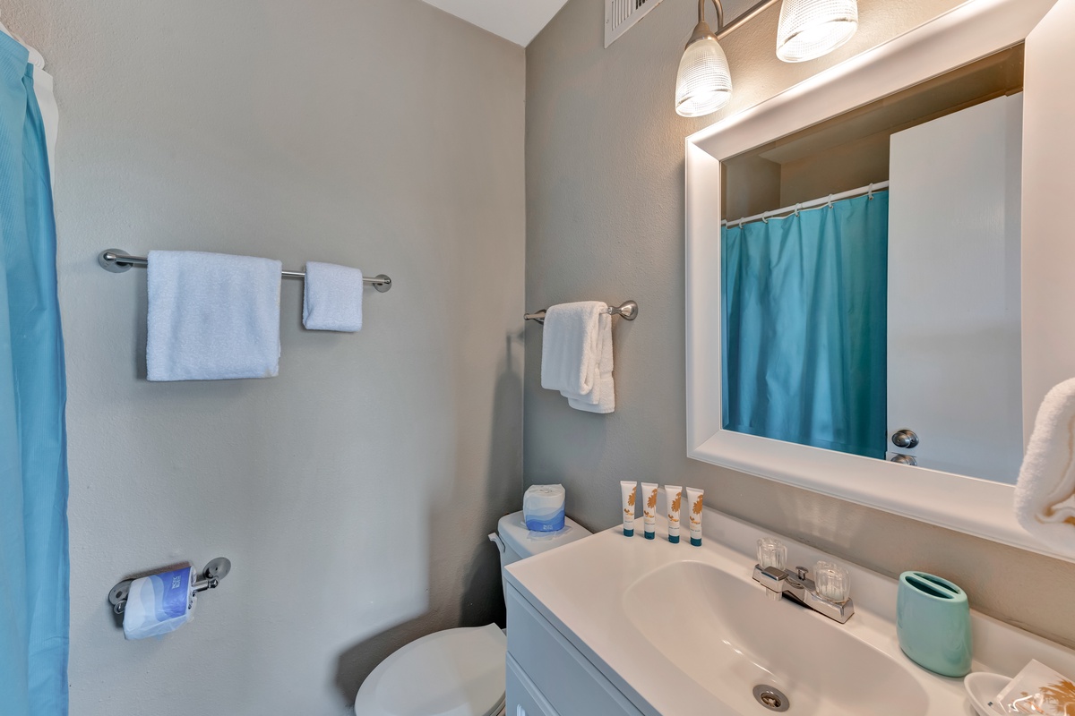 Step into your clean, well-appointed bathroom featuring fresh towels and thoughtful amenities for your comfort.