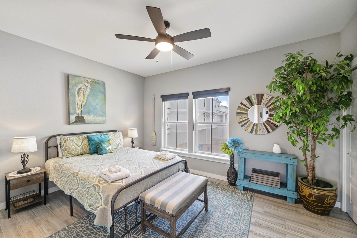 Unwind in your serene bedroom with coastal charm, featuring a comfortable bed and soothing décor for peaceful nights.