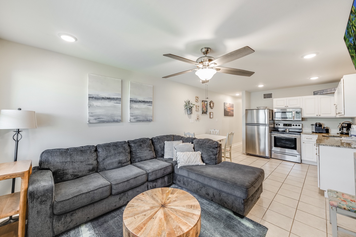 Unwind in your open-concept living space where coastal artwork meets modern comfort, complete with a full kitchen for home-cooked meals.
