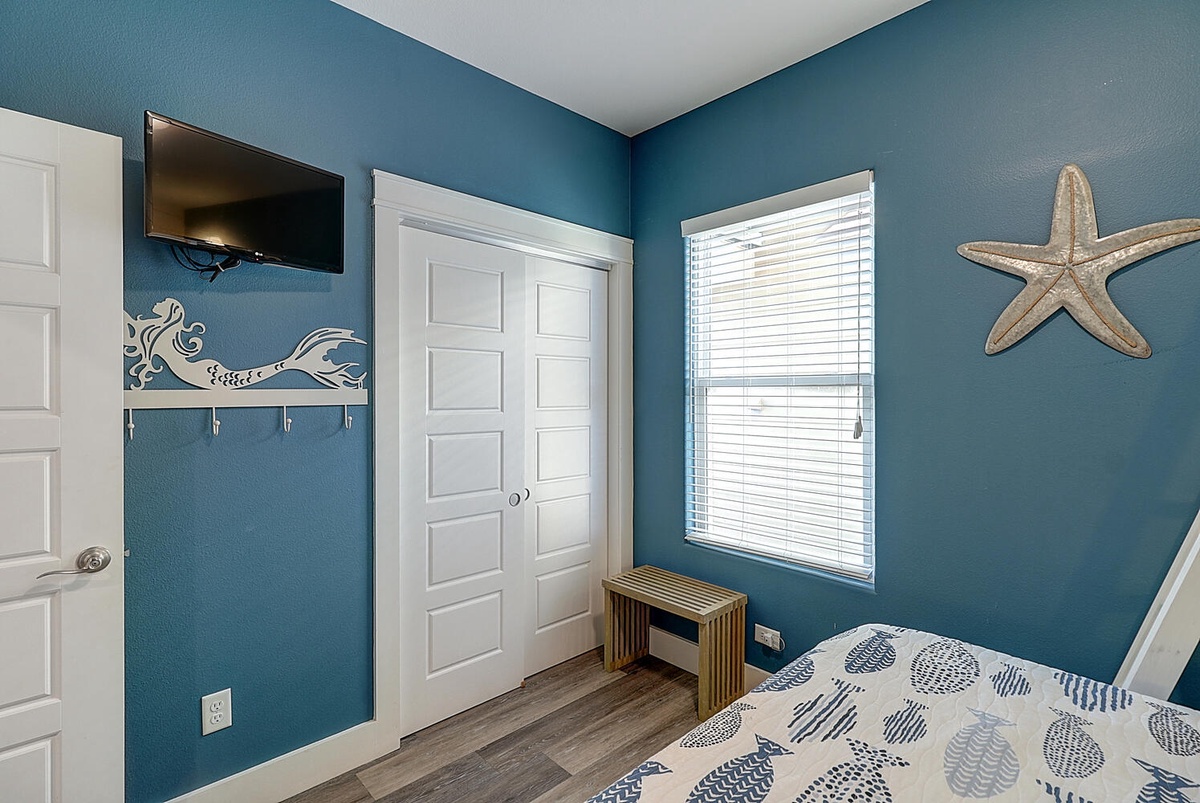Relax in your coastal bedroom with ocean blue walls, charming mermaid hooks, and peaceful starfish décor that transport you to seaside bliss.