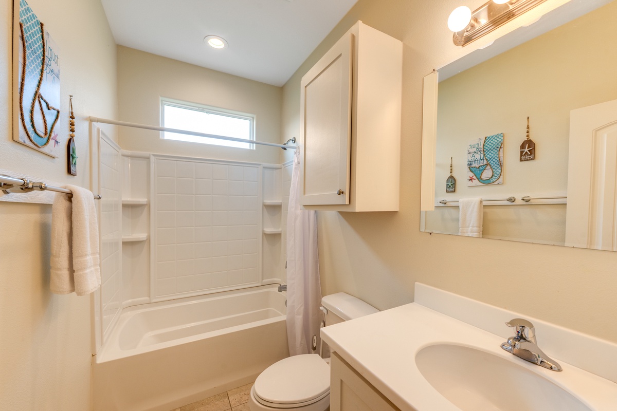 Step into your bright, well-appointed bathroom where nautical touches create a coastal vibe. Clean lines and thoughtful storage make your daily routine effortless.