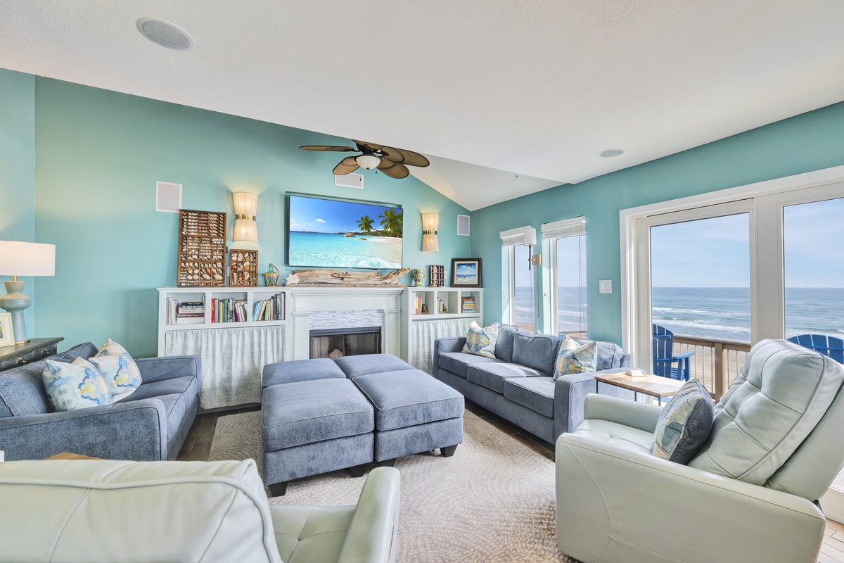 Sink into plush seating while ocean waves fill your view through floor-to-ceiling windows in this coastal-themed living room.
