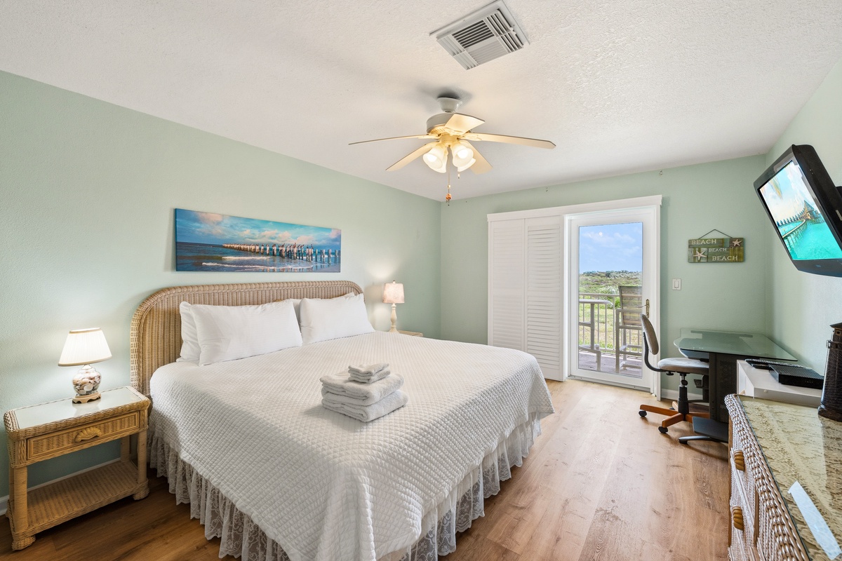 Drift off in your coastal-inspired bedroom, where soft seafoam walls and a plush king bed create pure relaxation. Step through the balcony doors to catch a breeze and take in the view.