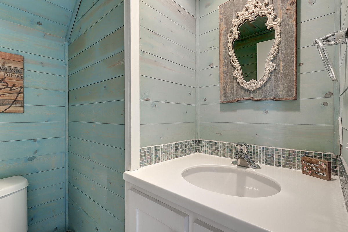 Refresh in your charming coastal bathroom with rustic shiplap walls and vintage mirror details.
