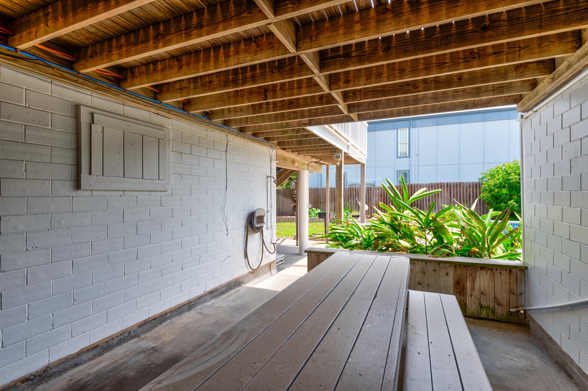 Your private covered patio offers a peaceful spot to unwind, complete with built-in seating and lush garden views.