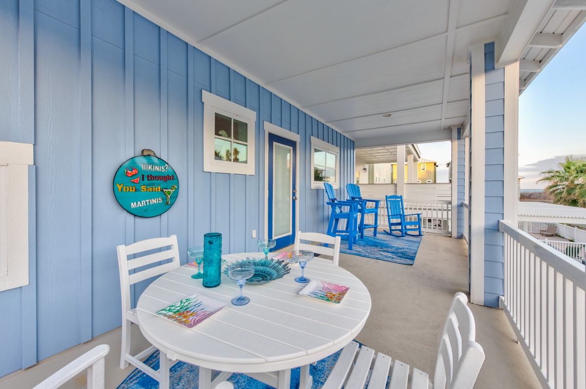 Relax on your private balcony with coastal charm - featuring outdoor dining table and colorful seaside decor perfect for morning coffee or evening cocktails.
