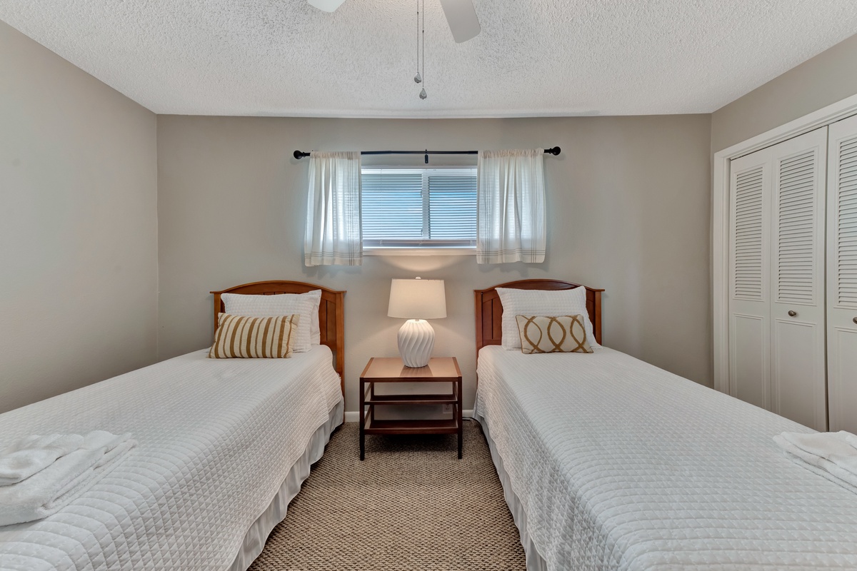 Rest peacefully in your twin bedroom with crisp linens and warm natural light streaming through the window.