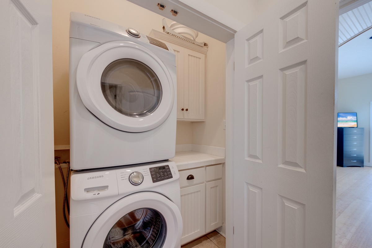 Your in-unit laundry room features a stacked washer and dryer with custom cabinetry for all your vacation needs.