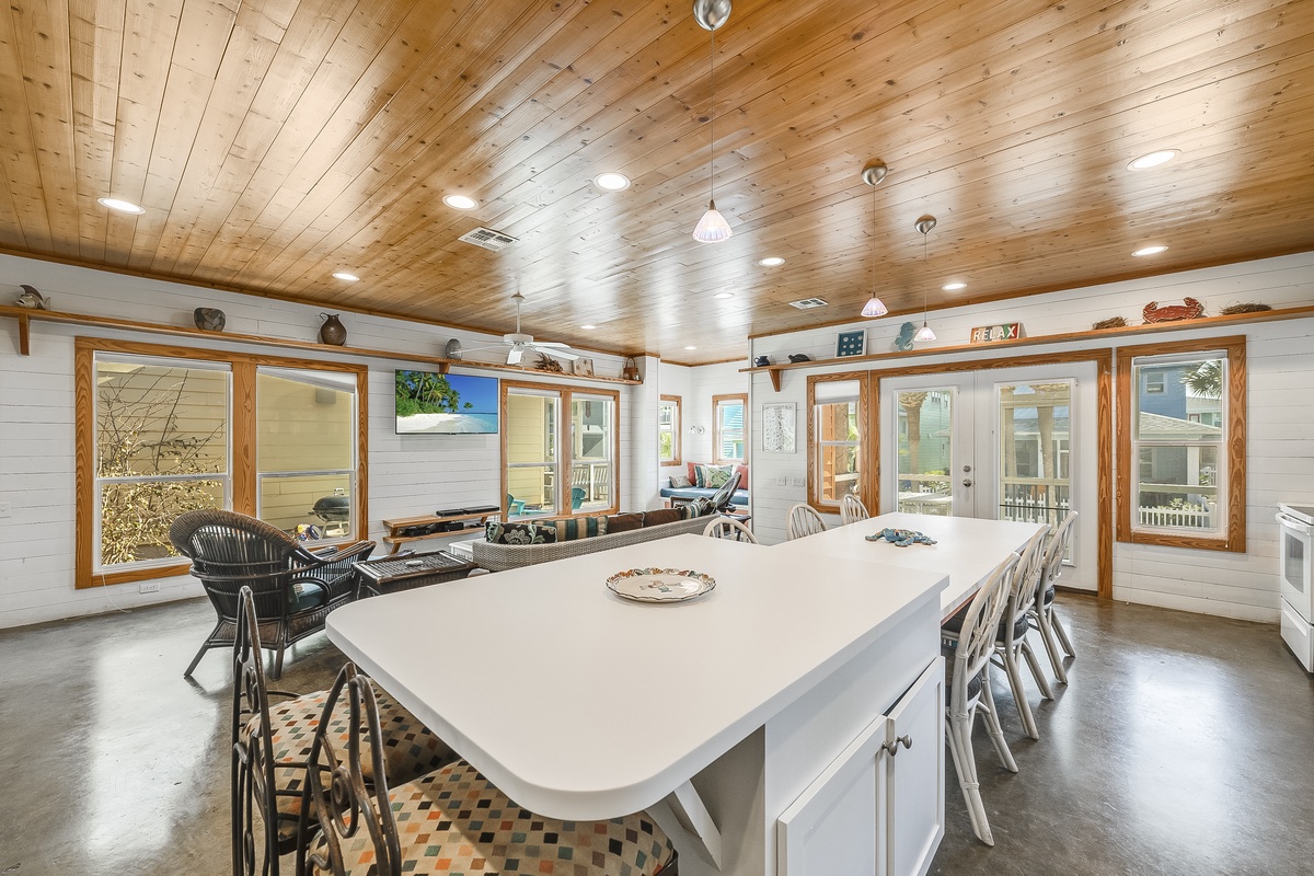 Gather around this stunning kitchen island where culinary adventures and memorable conversations unfold beneath beautiful wood-planked ceilings.