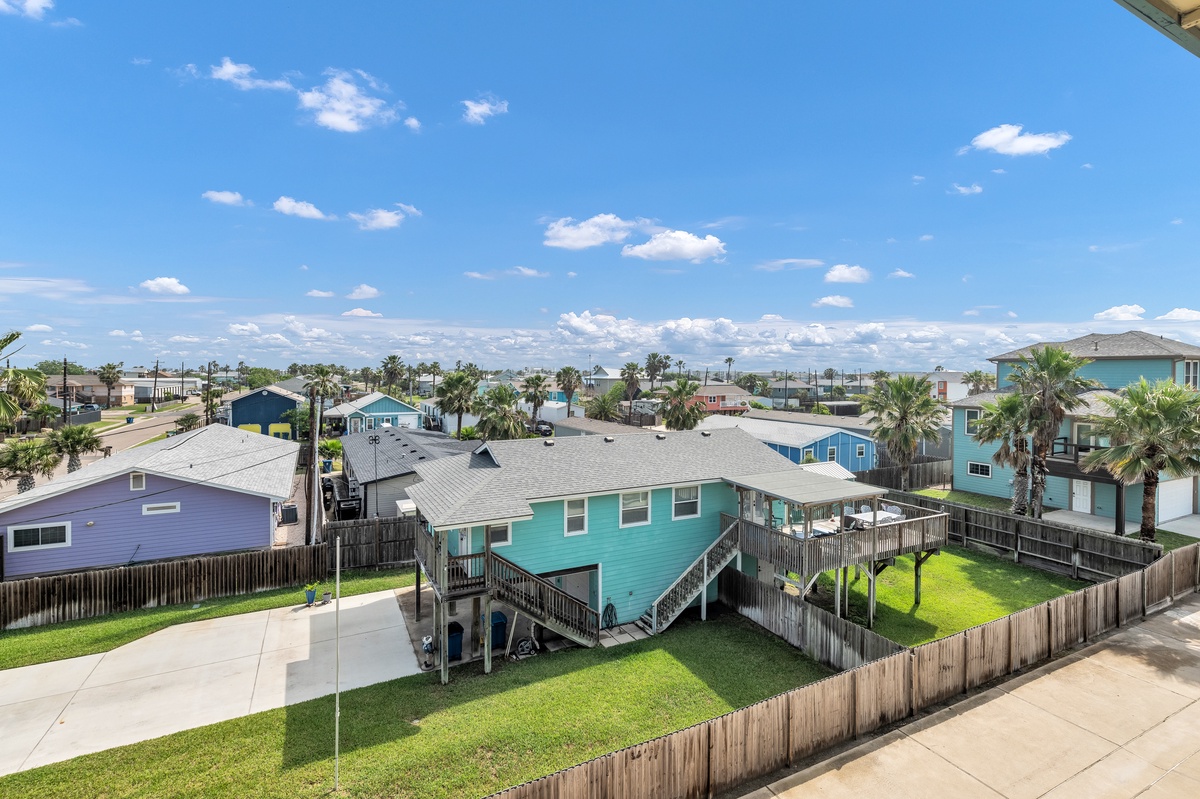 Elevated coastal neighborhood with colorful beach houses and palm trees stretching toward the horizon.