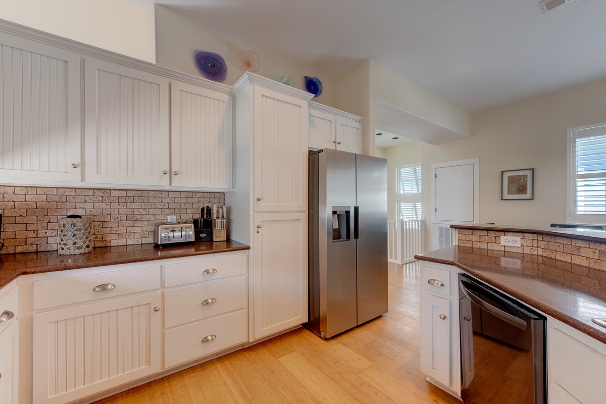 Your spacious kitchen features white cabinets, granite counters, and stainless steel appliances, creating the perfect space for preparing home-cooked meals during your stay.