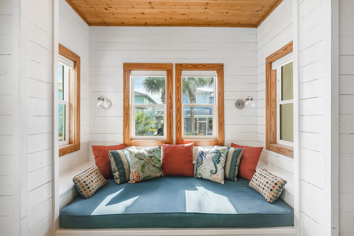 Curl up in your cozy window nook with tropical views, where coastal pillows and soft light create the perfect reading retreat.