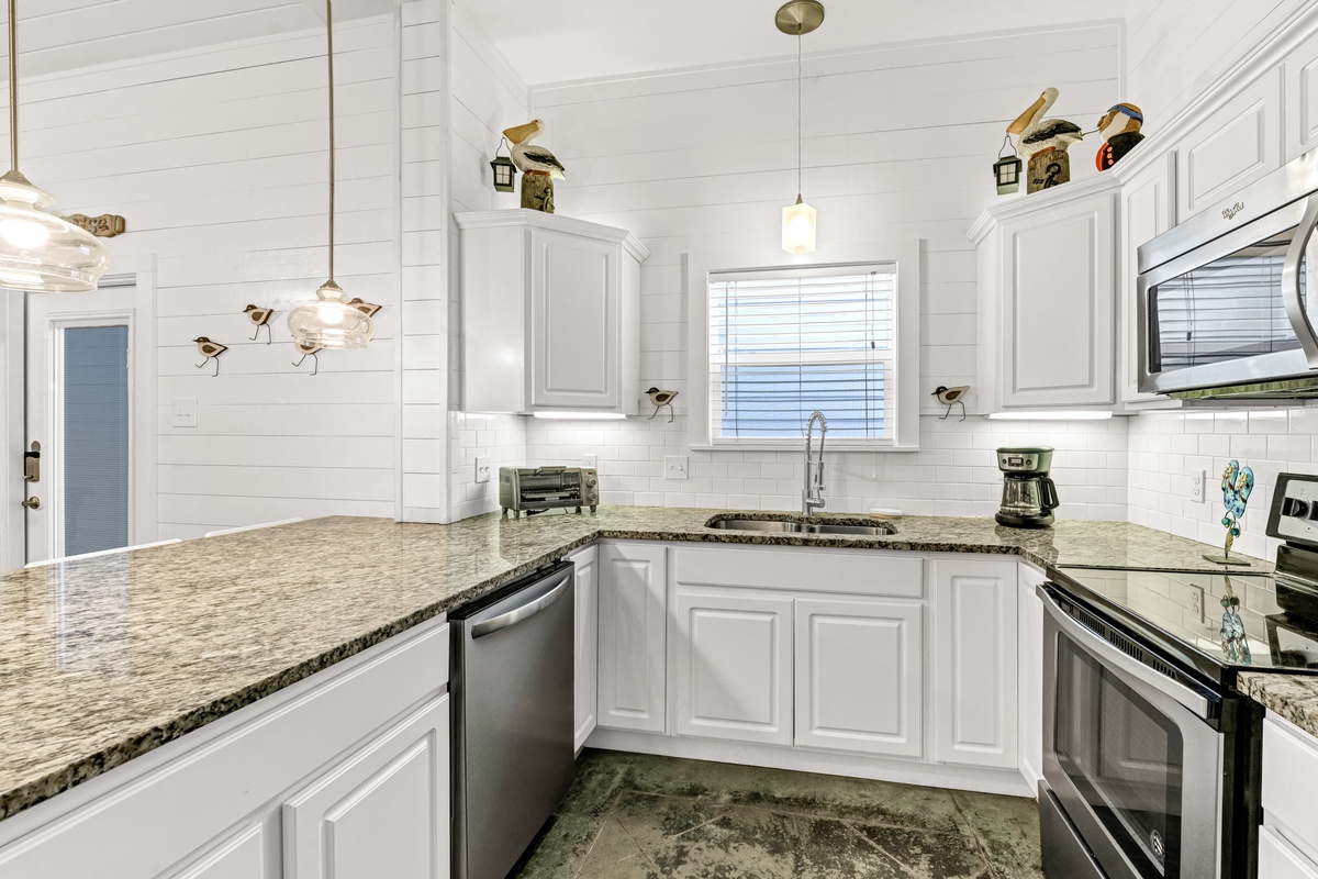 Your fully equipped kitchen features granite countertops, stainless appliances, and charming coastal decor to inspire culinary adventures.