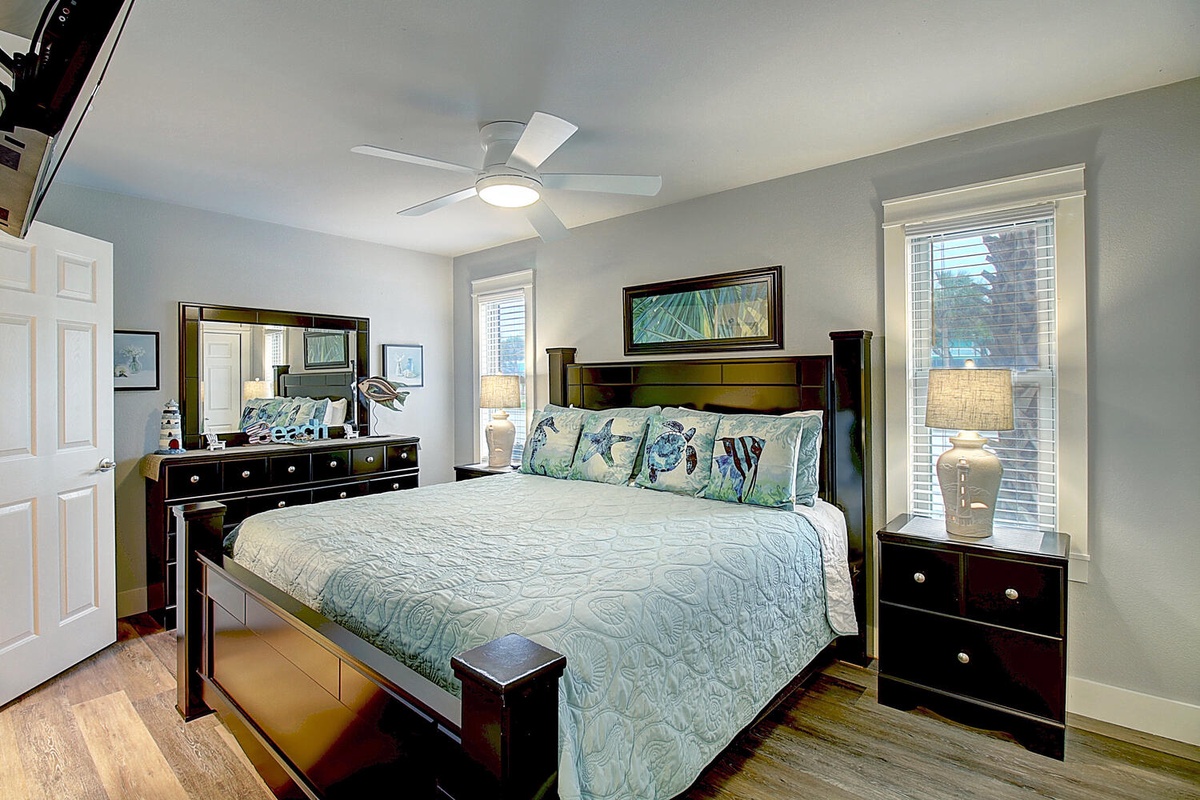 Drift into peaceful sleep in your elegant bedroom with rich wood furnishings and coastal accents creating the perfect retreat.