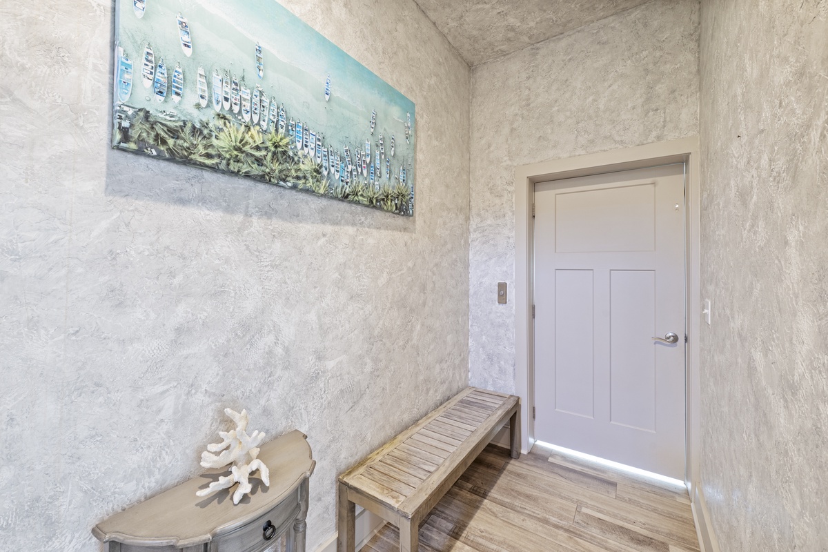 Step into your coastal-themed entry where weathered walls and beach artwork welcome you home after days exploring.