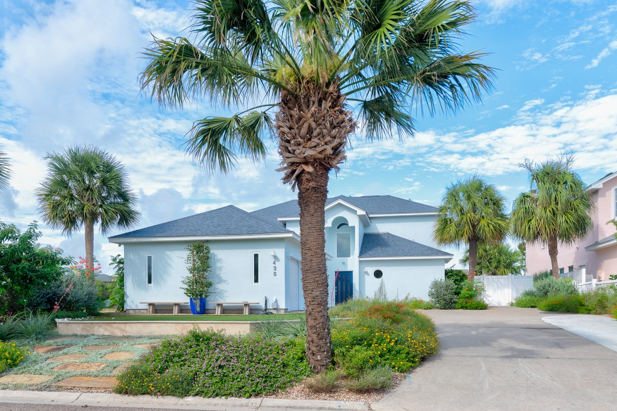 A charming coastal retreat framed by swaying palms and lush landscaping, set in a peaceful neighborhood just moments from the beach.