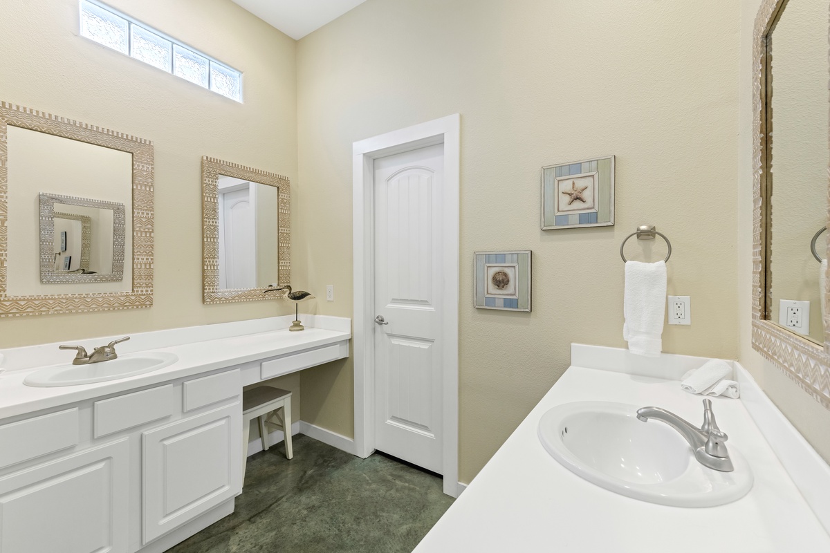 Unwind in this elegant coastal-themed bathroom with dual sinks, designer mirrors, and thoughtful nautical touches.