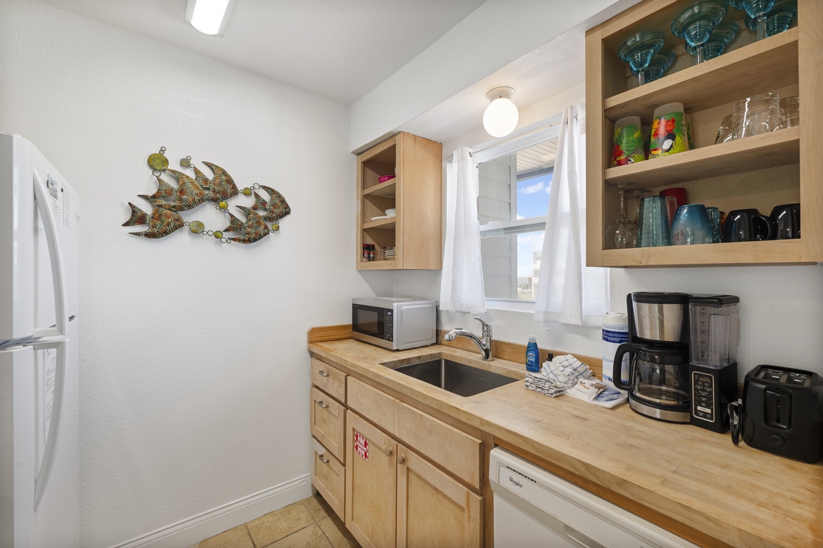 Your fully equipped kitchen features everything you need for a comfortable stay, from coffee maker to microwave, all in a bright, welcoming space.