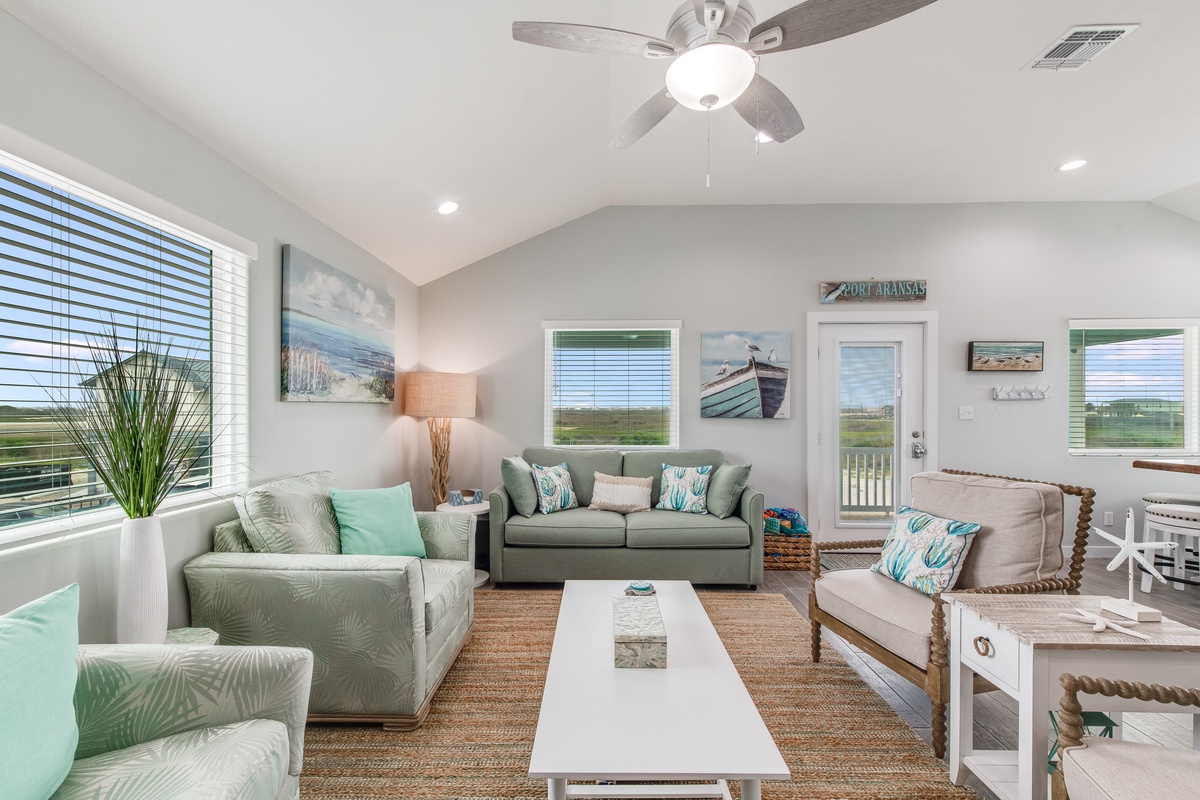 Sink into coastal-inspired comfort in your bright living space, where soft sea-glass hues and beach artwork create your perfect retreat.