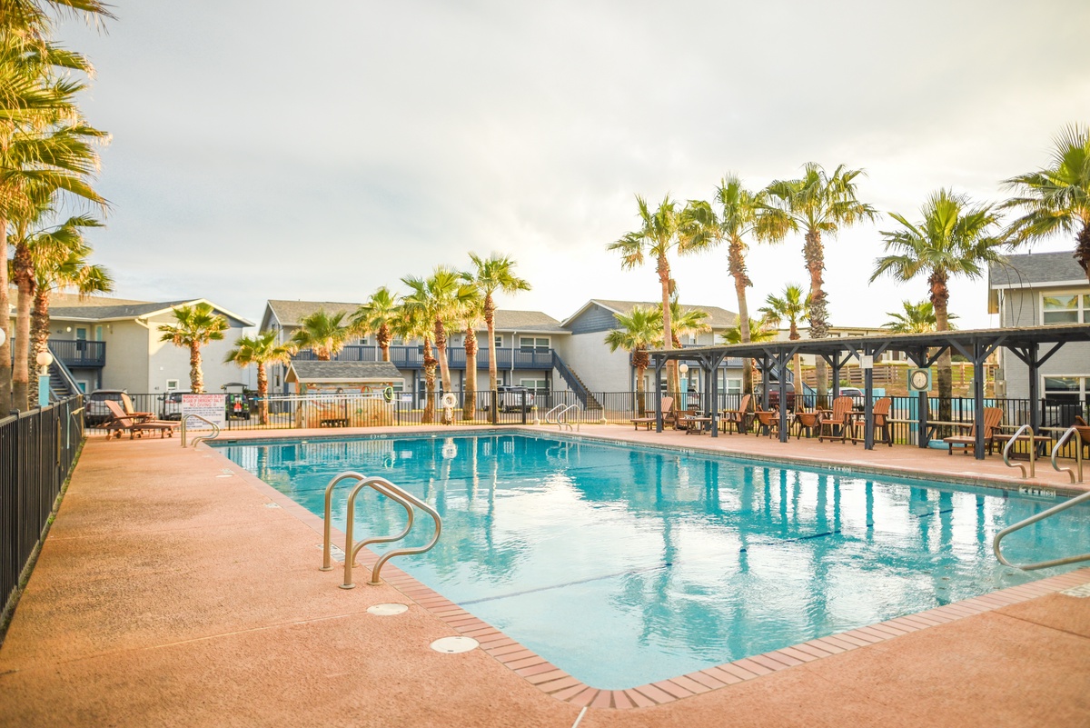 Dive into crystal-clear waters surrounded by swaying palms - your tropical escape awaits in this serene poolside paradise.