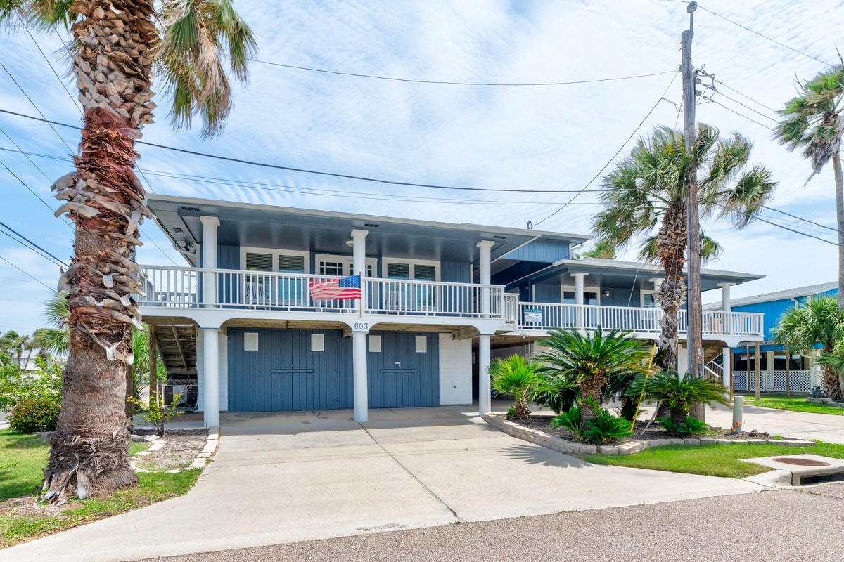 A charming coastal home with tropical palm trees and covered parking in a peaceful residential neighborhood.