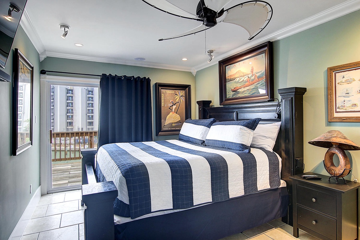 Unwind in your nautical-themed bedroom featuring crisp blue and white linens, coastal artwork, and balcony access for ocean breezes.