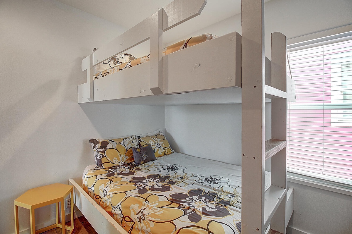Sleep soundly in your cozy bunk bed with cheerful floral bedding and natural light streaming through the window.