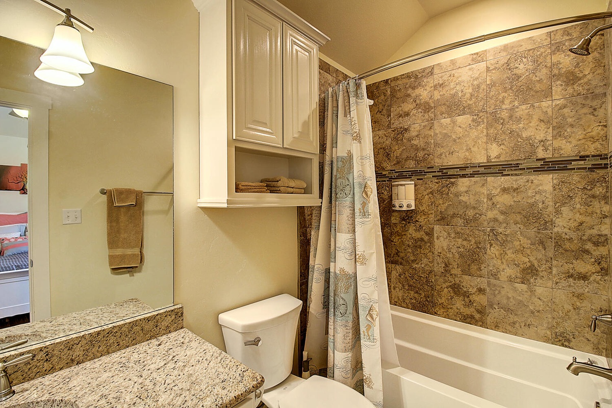 Relax in your elegant bathroom featuring granite counters, beautiful tile work, and a deep soaking tub for unwinding after your adventures.