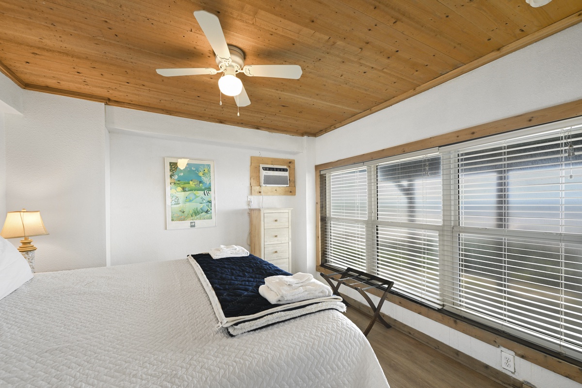 Drift off under warm wood ceilings and a gentle ceiling fan. Your restful retreat features a plush bed with fresh linens and artwork that brings seaside charm inside.