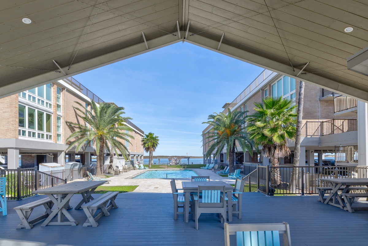 Relax under your covered pavilion with pool views, palm trees swaying, and comfortable seating for dining and lounging.