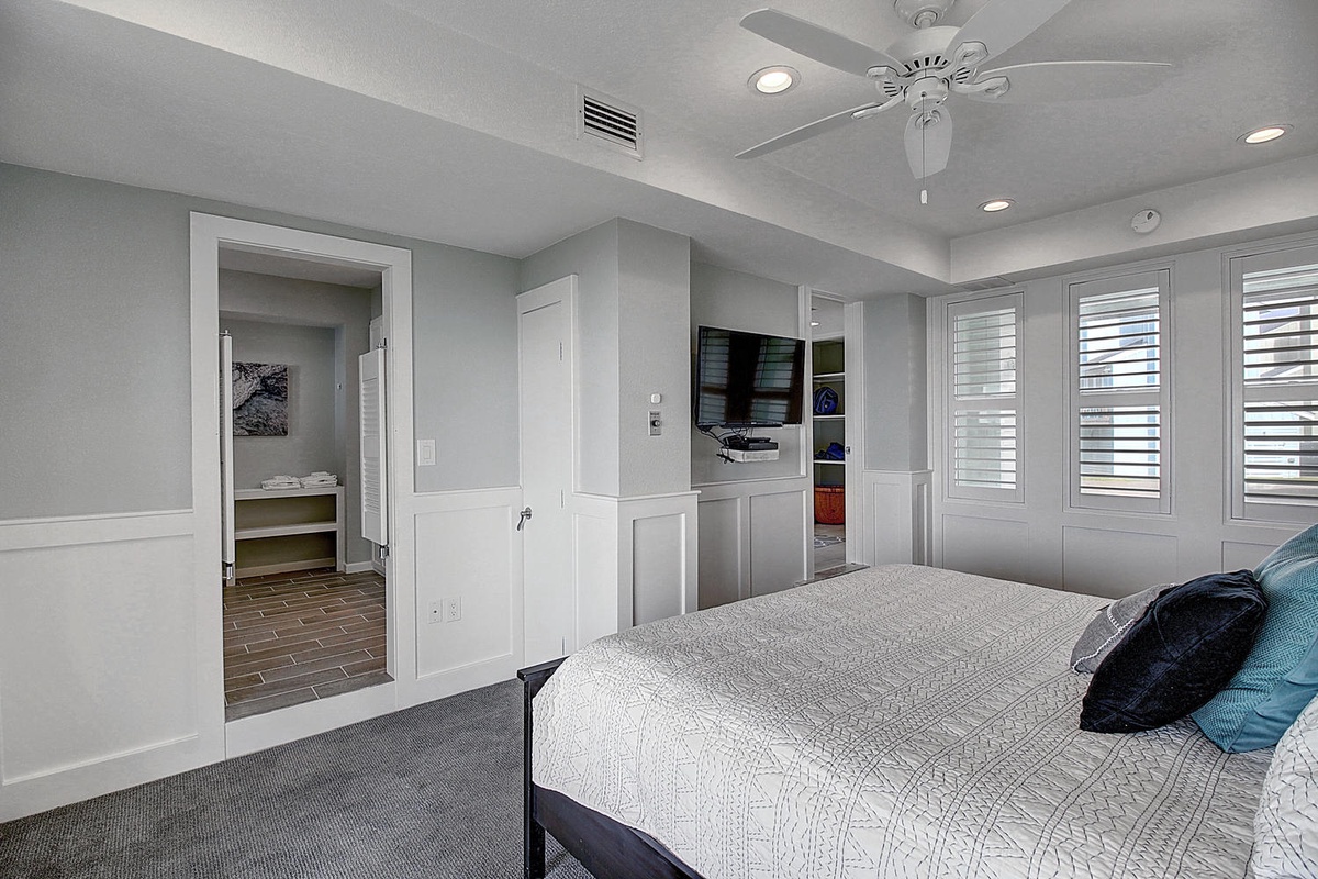 Your spacious bedroom features elegant gray tones, a ceiling fan for comfort, and an ensuite bathroom for ultimate convenience.