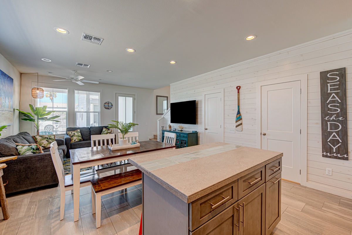 Relax in your stylish open living space with modern kitchen island, cozy seating, and coastal charm throughout.