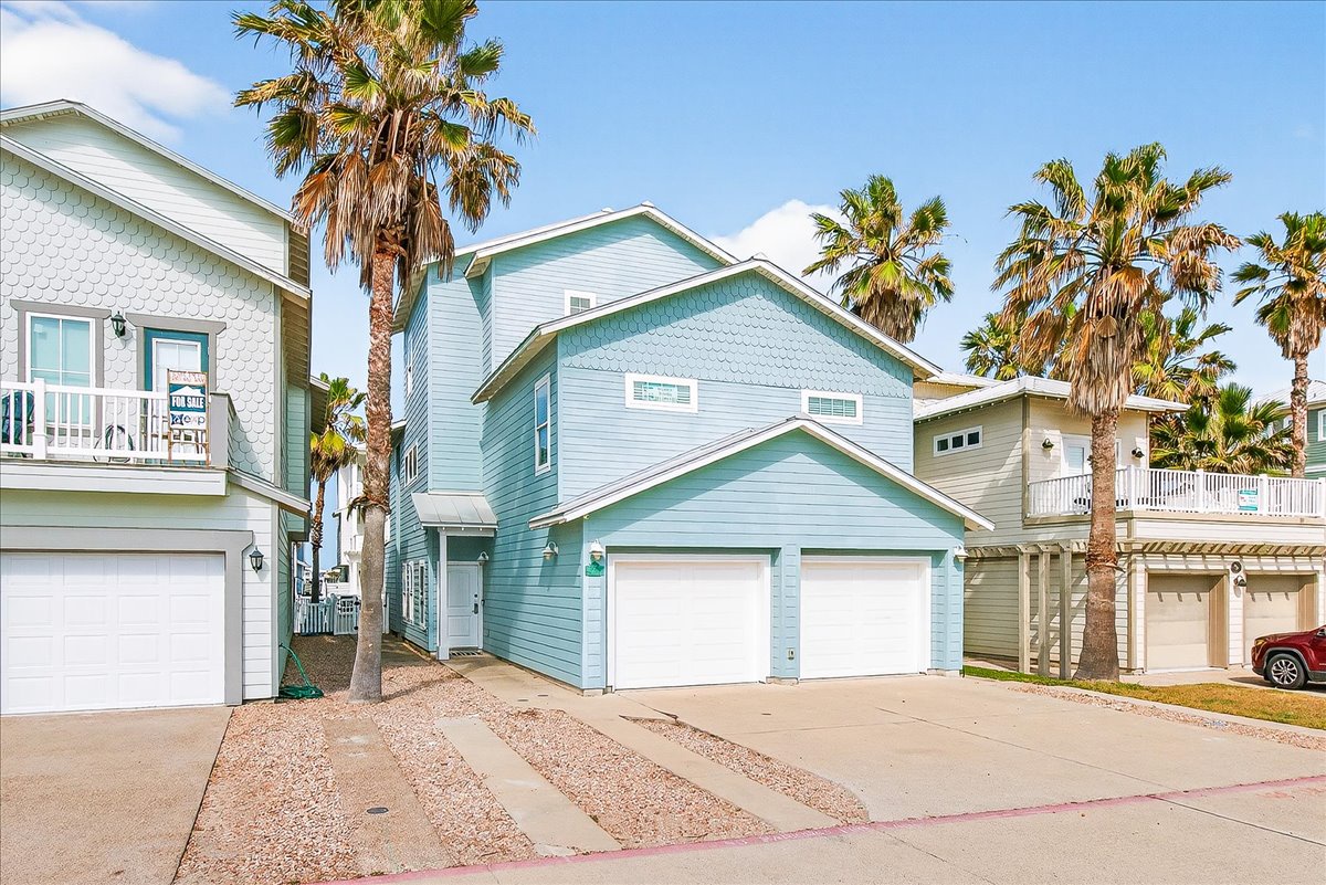 Charming coastal property surrounded by swaying palm trees creates a perfect tropical escape in a vibrant beach community setting.