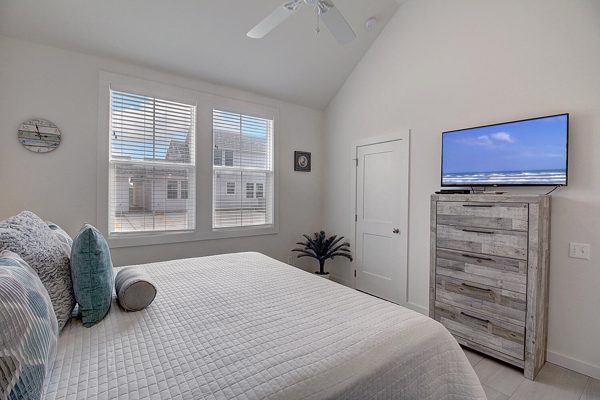 Relax in your coastal-inspired bedroom with ocean views on screen and weathered wood furnishings for your perfect beach getaway.