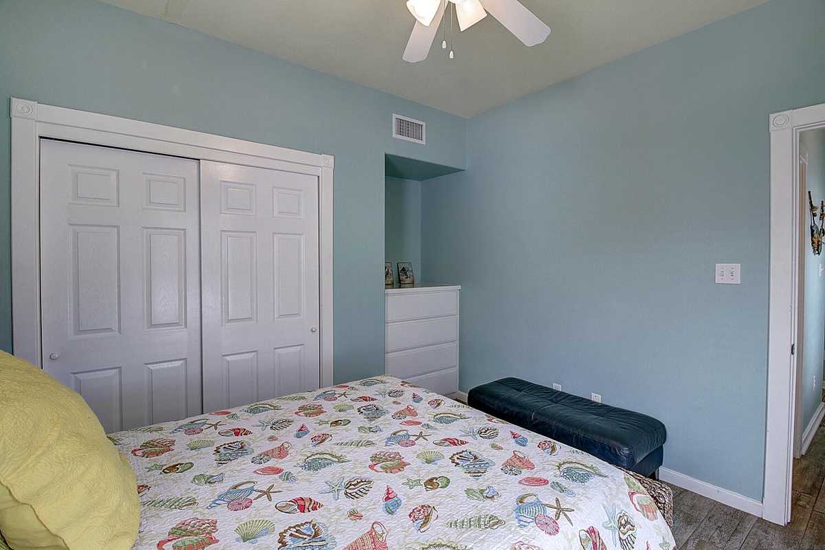Drift off in your bright coastal bedroom, featuring colorful ocean-themed bedding and refreshing turquoise walls that'll lull you to sleep.