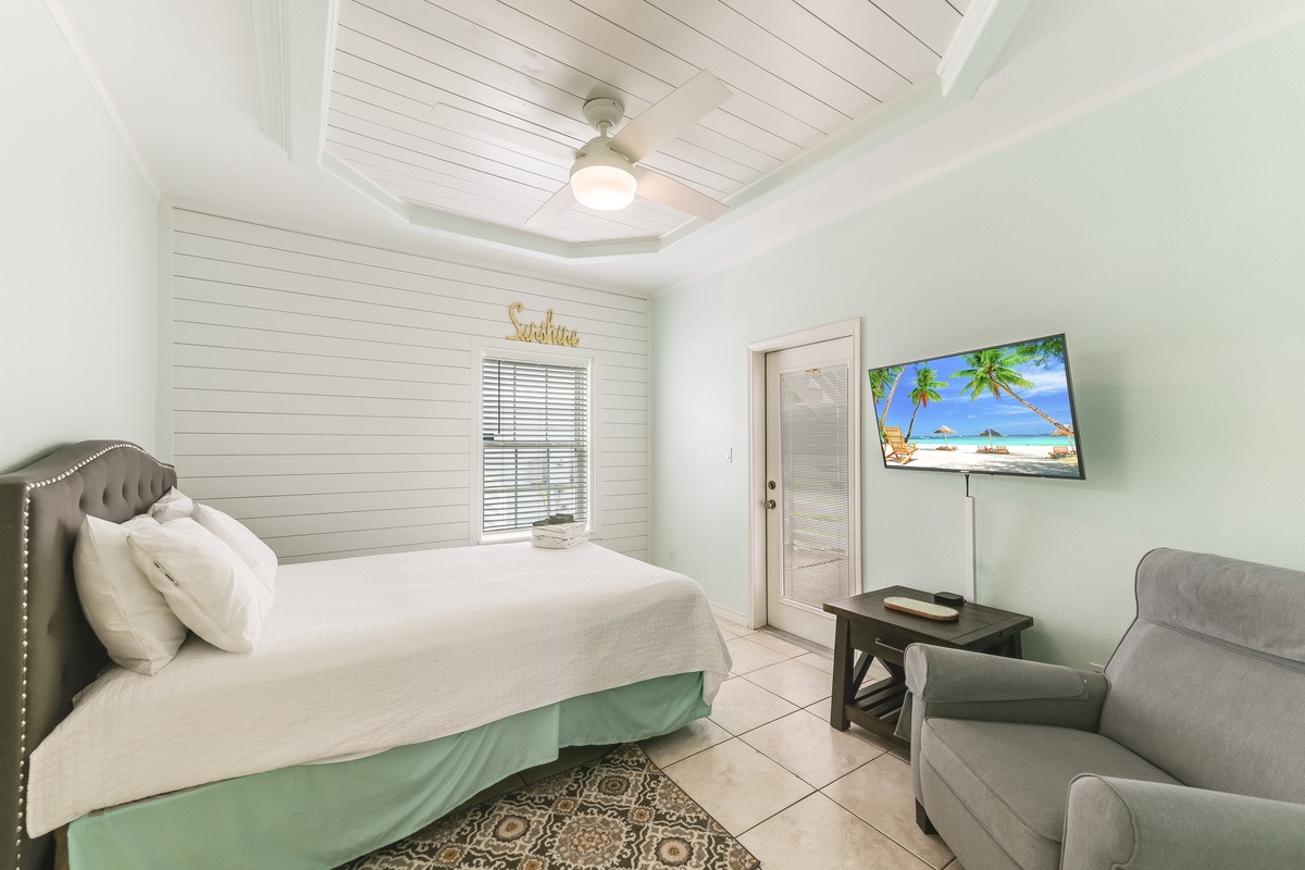 Unwind in your coastal-inspired bedroom with a plush king bed, comfortable seating area, and tropical views on the flat-screen TV.