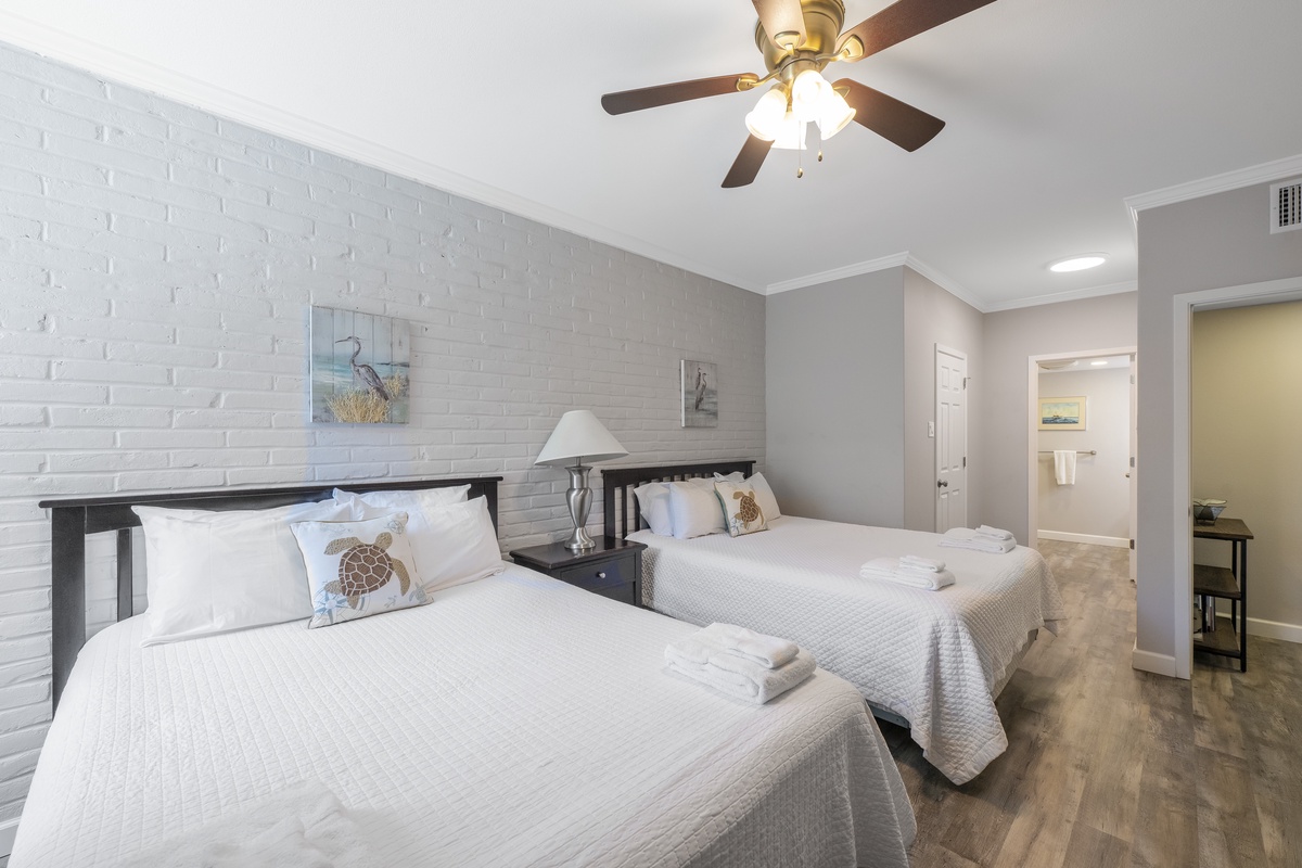 Rest peacefully in your comfortable twin bedroom with coastal charm, featuring soft linens and a gentle ceiling fan breeze.