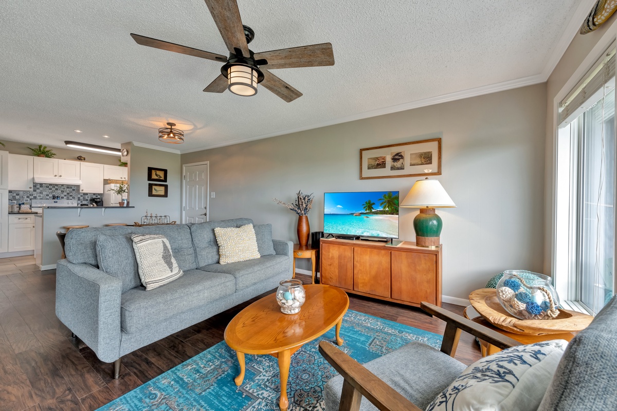 Unwind in your stylish living room with comfortable seating, ceiling fan, and TV for cozy evenings after exploring.