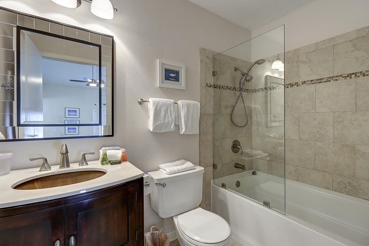 Unwind in your elegantly appointed bathroom featuring natural stone accents and a luxurious tub-shower combination.