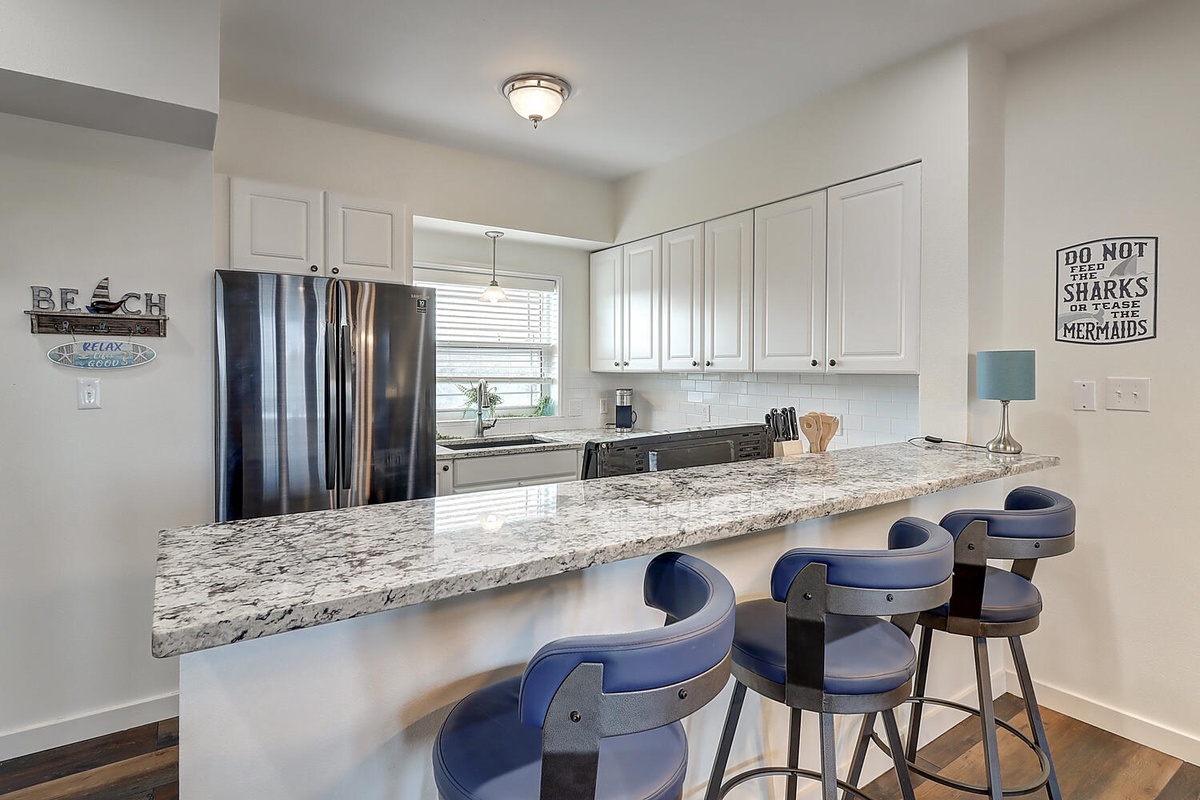 Your fully equipped kitchen offers granite countertops, stainless steel appliances, and a breakfast bar perfect for morning coffee or casual meals.