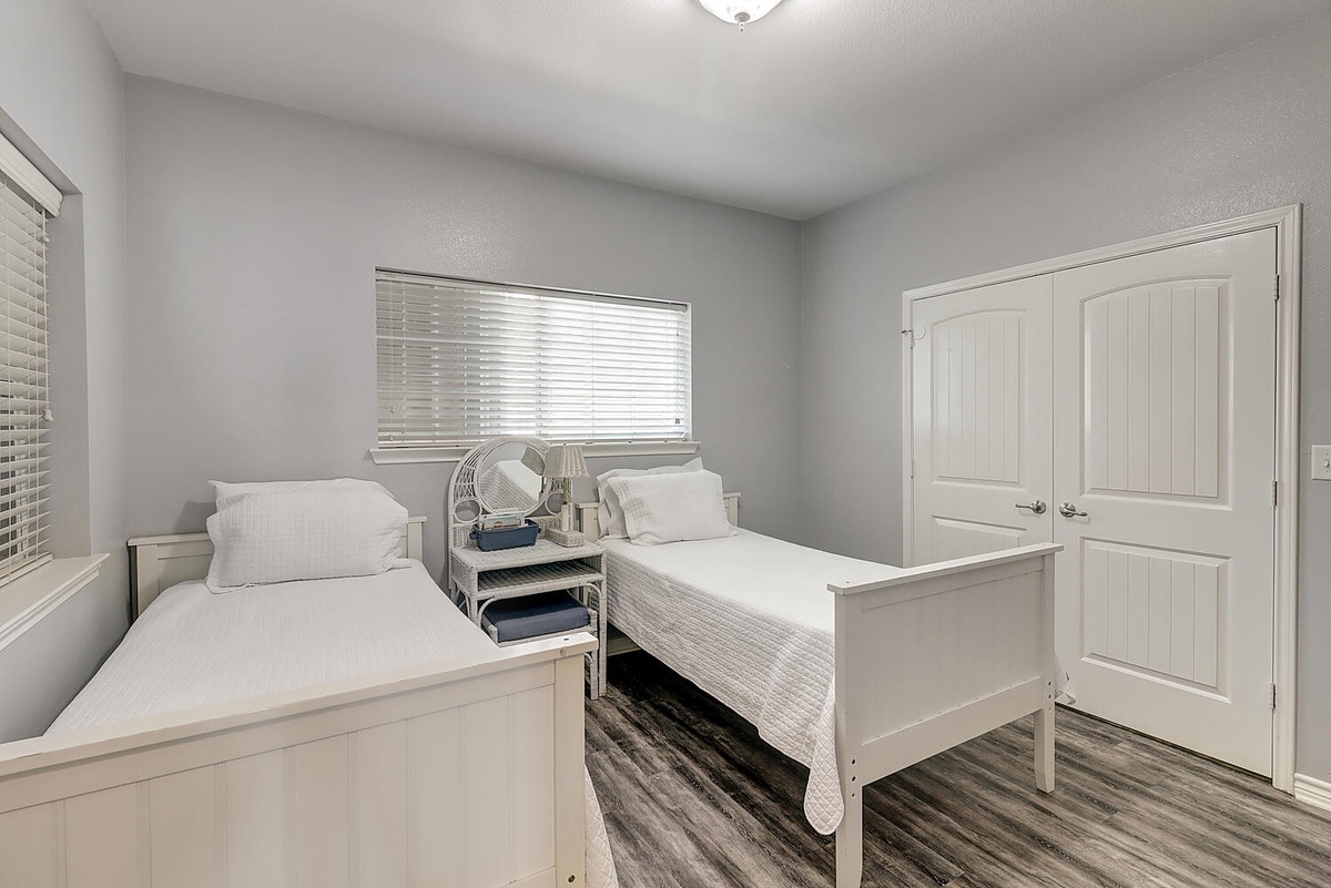 Unwind in your peaceful twin bedroom featuring crisp white linens and modern comfort for restful nights.