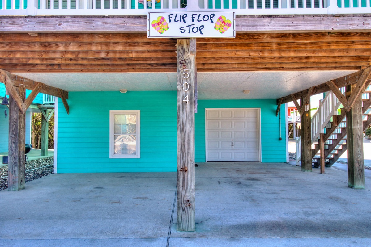 Covered parking area with charming Flip Flop Stop sign marking unit 504, featuring convenient ground-level access and secure storage.