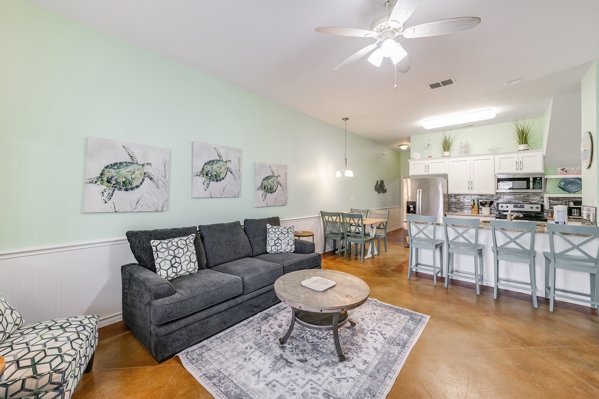 Relax in your bright, coastal-themed living space where sea turtle art and soft colors create a peaceful beach vibe.