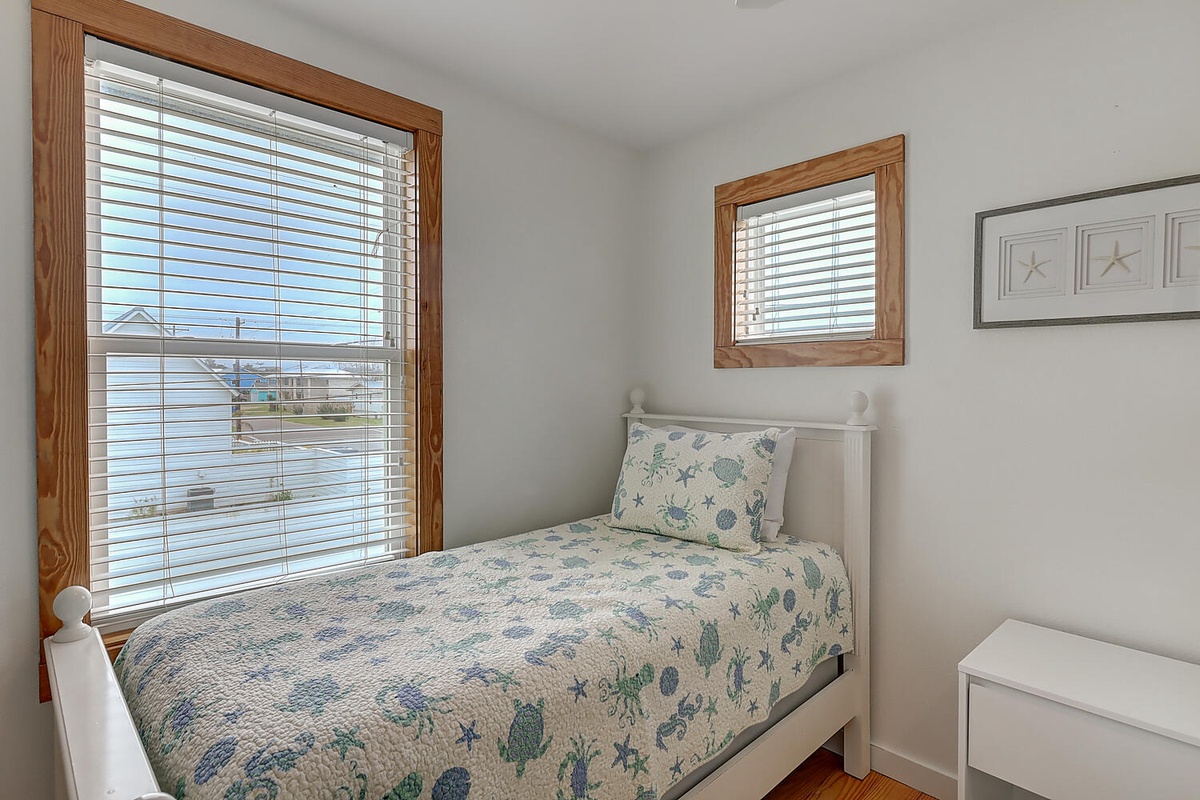 Drift off peacefully in your charming coastal bedroom, where soft sea-themed linens and warm wood accents create the perfect seaside retreat.