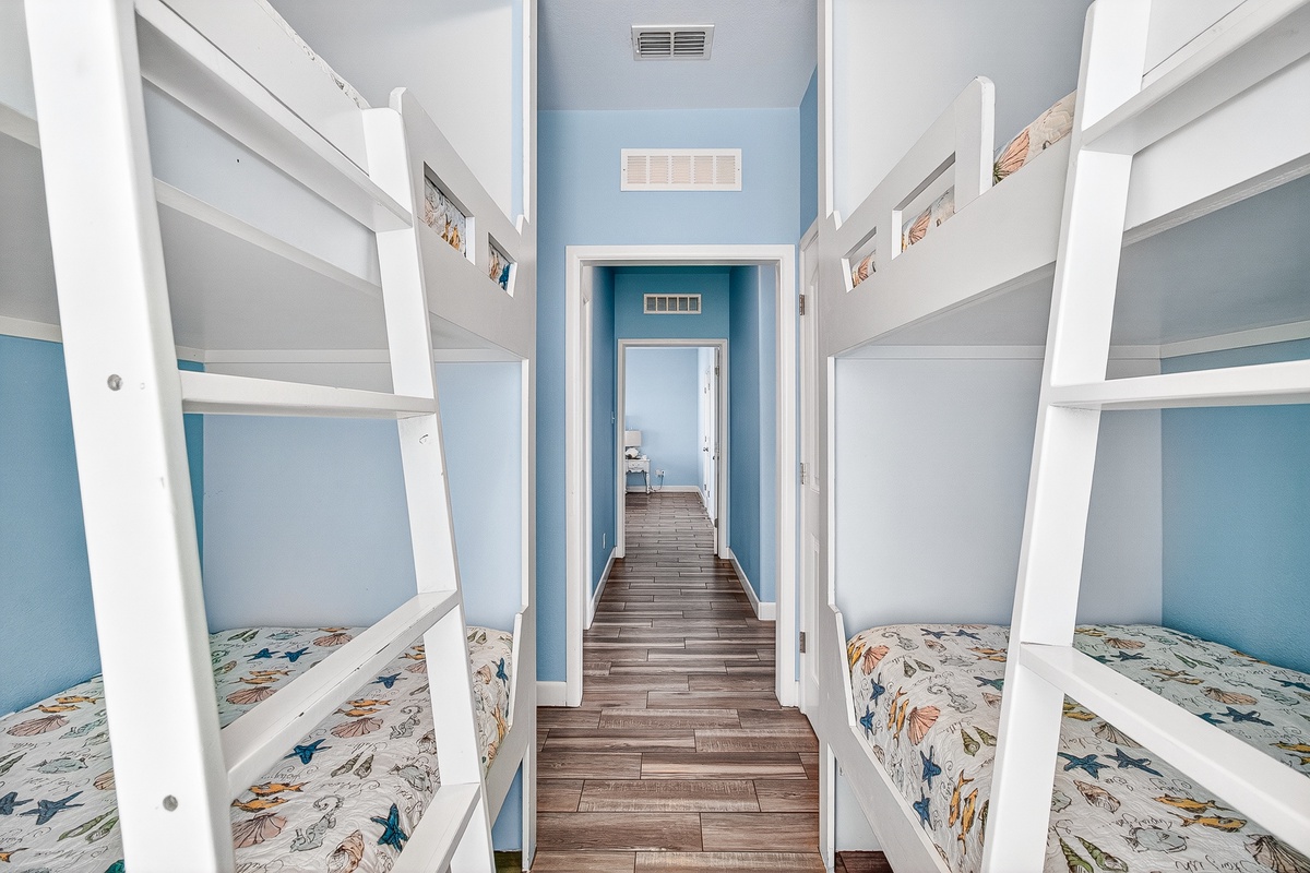 Your kids will love these cozy bunk beds with ocean-themed bedding in this cheerful blue bedroom designed for fun family stays.