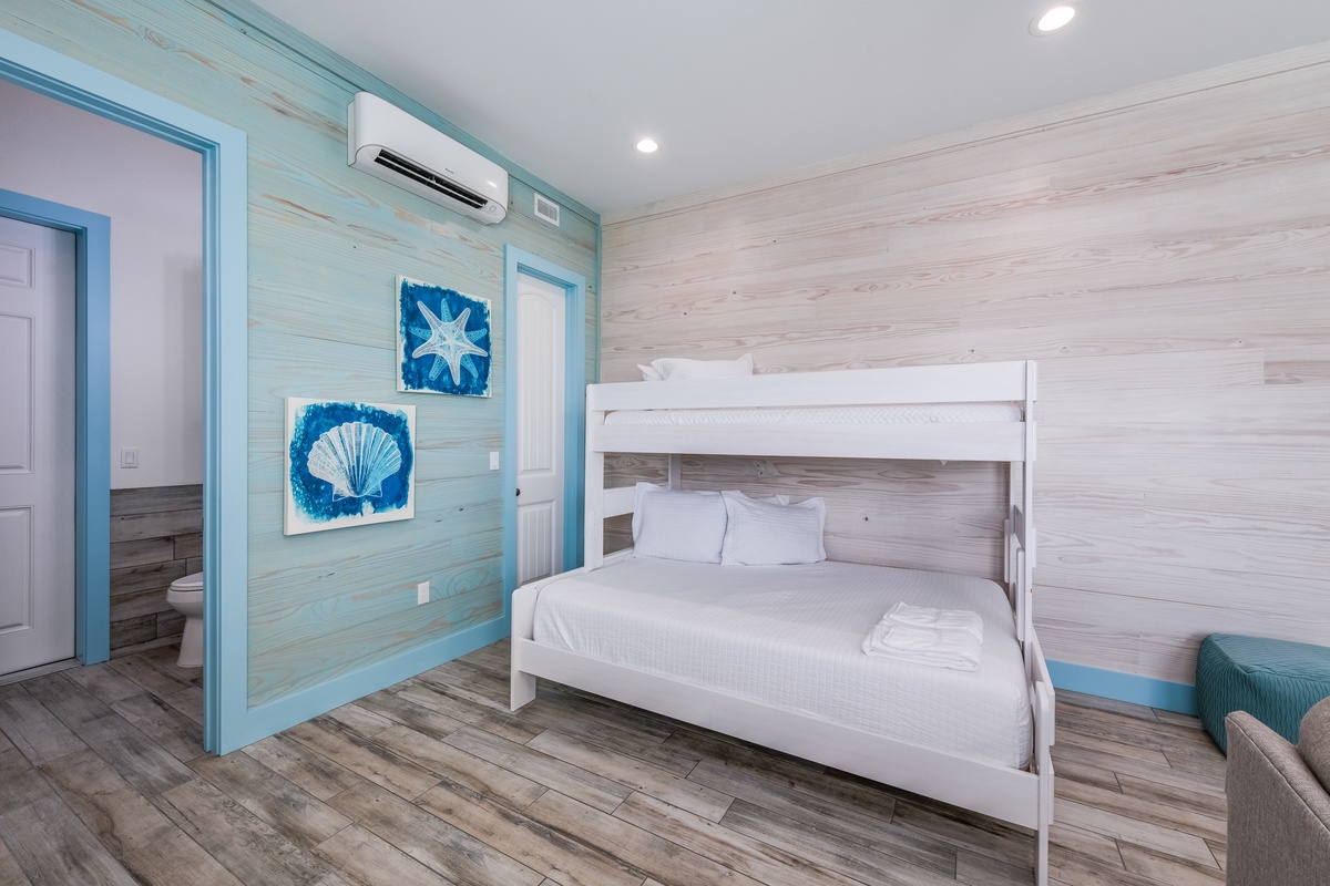 Your coastal-themed bunk room features ocean-inspired artwork and comfortable sleeping for the whole family in this bright, airy space.