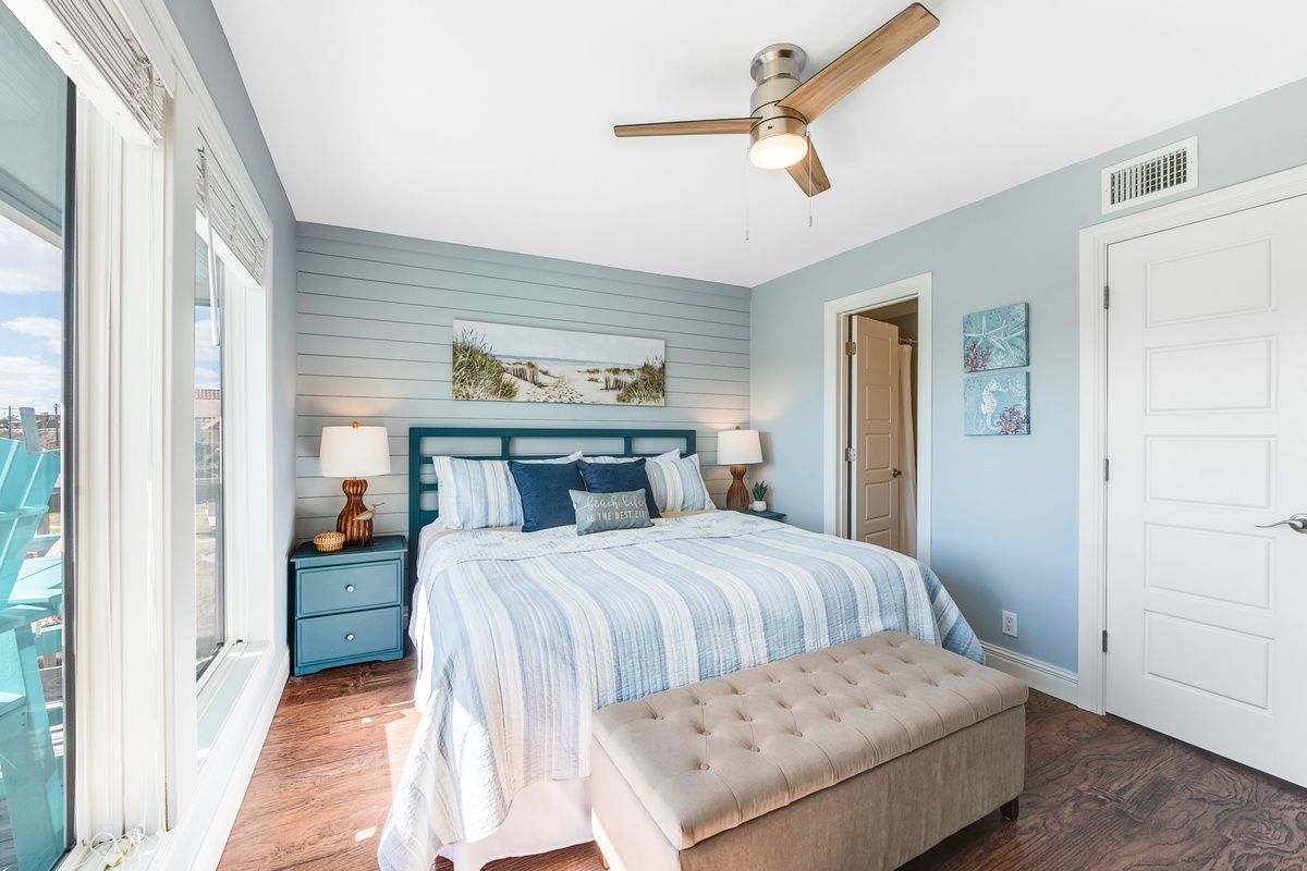 Drift off to sleep in this coastal-inspired bedroom with soothing blue tones, comfortable bedding, and city views from your window.