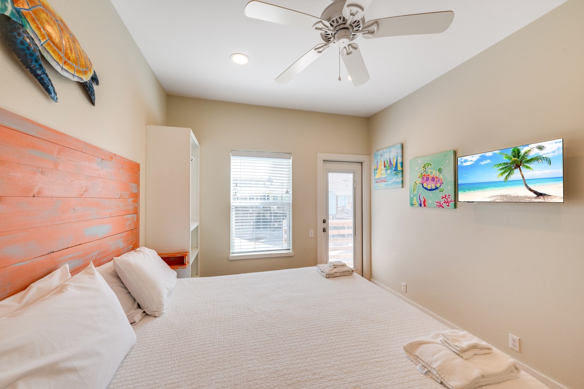 Drift off in your coastal-themed bedroom with vibrant beachy art, crisp linens, and gentle ceiling fan breezes.