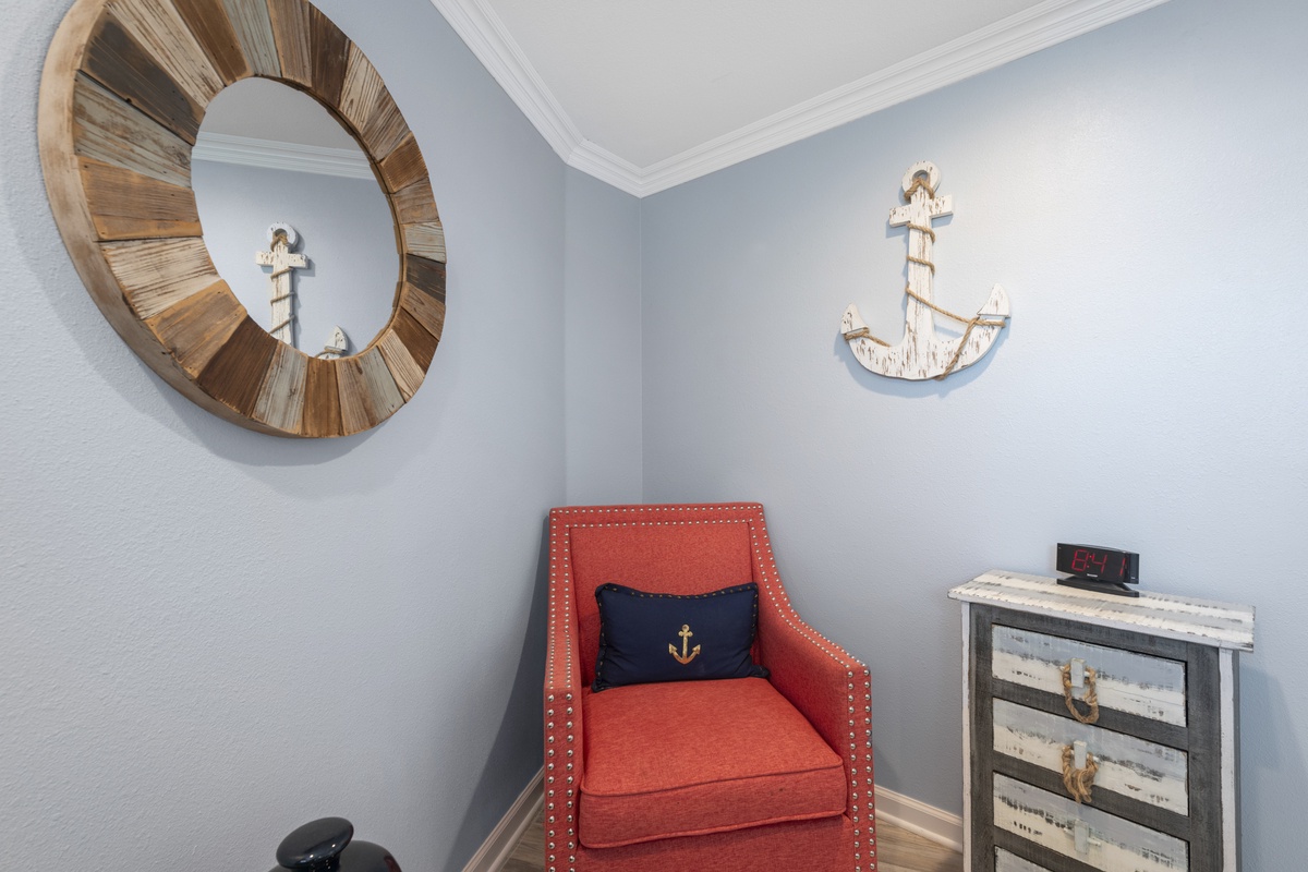 Relax in your cozy nautical reading nook with coral armchair and charming coastal decor throughout.